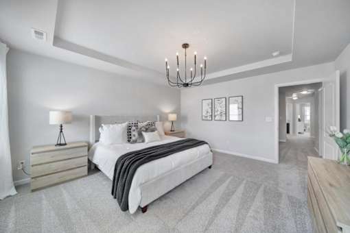 Spacious bedroom with large bed and chandelier in pet-friendly townhome in Indian Trail, NC