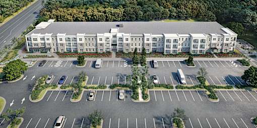 Aerial view of Sage 5430 Senior Apartments in Norcross, Georgia, showing landscaped grounds, multiple residential buildings, and ample parking in a pet-friendly senior community.