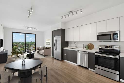 Modern apartment kitchen at MB Station featuring white cabinetry, quartz countertops, stainless steel appliances, and an open-concept layout in Coral Way, Miami.