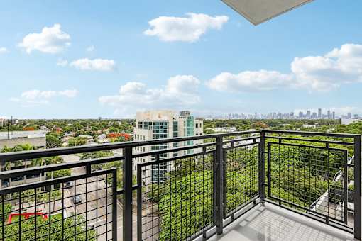 Private apartment balcony at MB Station overlooking Coral Way with expansive city skyline views near Brickell and Downtown Miami.