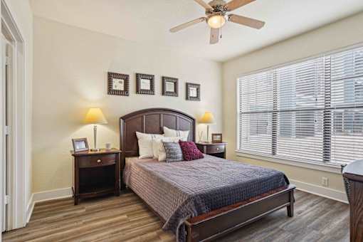 1, 2 -Bedroom Apartments for Rent in North Little Rock, AR – Metropolitan– A bedroom with a bed, nightstands, and a ceiling fan.