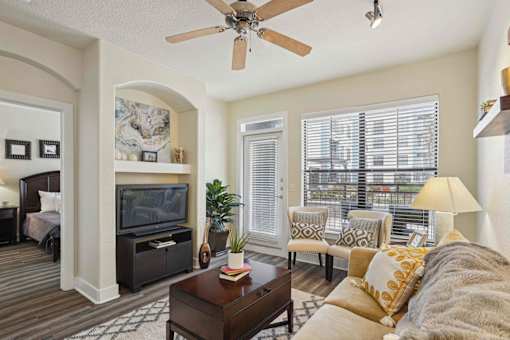 1, 2 -Bedroom Apartments for Rent in North Little Rock, AR – Metropolitan– A living room with a brown carpet and a white ceiling fan.