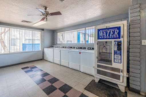 A room with a water heater and a ceiling fan.