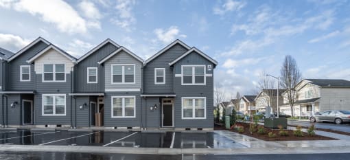Apartments Near Lake Vancouver, WA - Minnehaha Meadows - An Off-Street Parking Fronting a Row of Apartments, Landscaping, and View of Nearby Apartments.