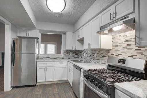 Modern kitchen with stainless steel appliances and designer backsplash at Mirador at Idlewood in Clarkston, GA near Stone Mountain and East Atlanta