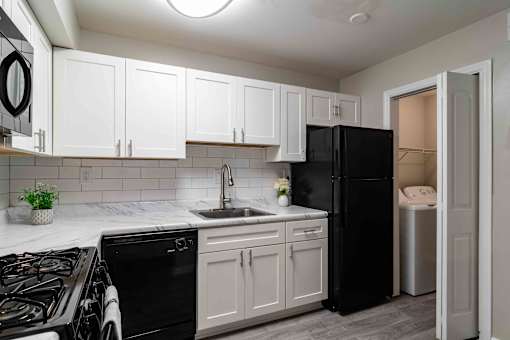 Kitchen with black appliances and open layout in renovated Atlanta rental apartment.
