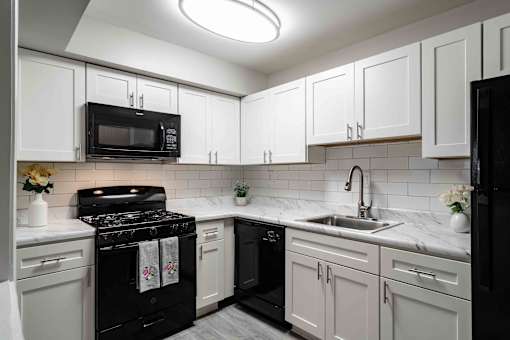 Kitchen with gas stove and white cabinets in updated apartment at Mirador at Peachtree.