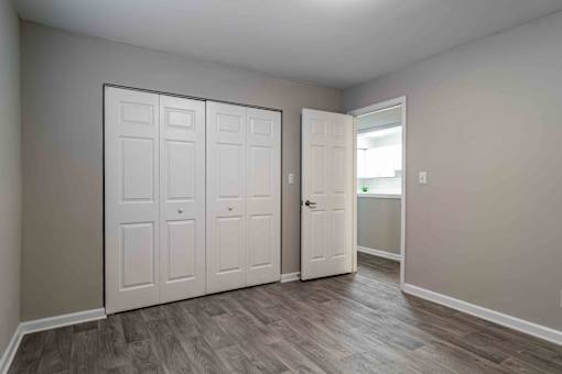 Bedroom with double-door closet and neutral paint in Atlanta rental apartment.