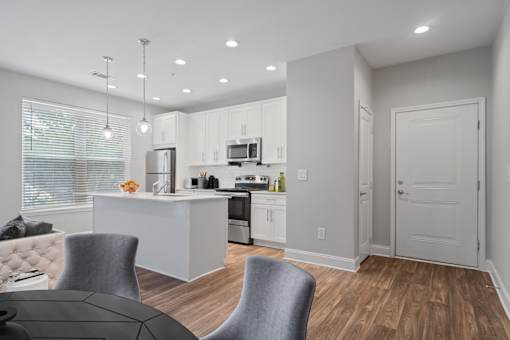 Dining space with bar seating and pendant lighting in a renovated Atlanta apartment.