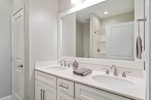 Bathroom with single-sink vanity, mirror, and bright lighting in updated Atlanta apartment.