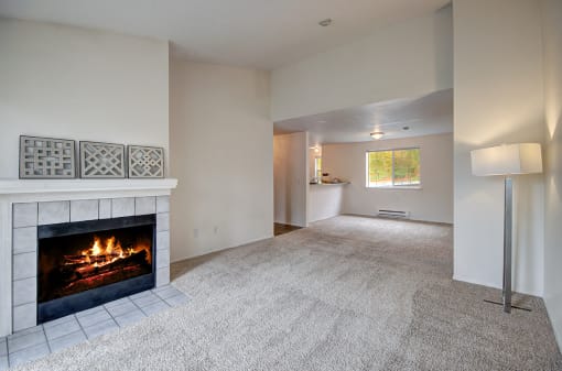 Apartments for Rent in Bothell WA - North Creek Heights - Empty Living Room with Carpeted Floor, Floor Lamp, and Fireplace