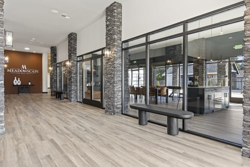 a spacious lobby with wood floors and glass doors,