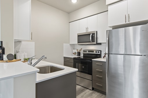 a kitchen with stainless steel appliances and white cabinets,