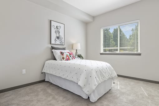 an spacious bedroom with a bed and a window for natural lighting,