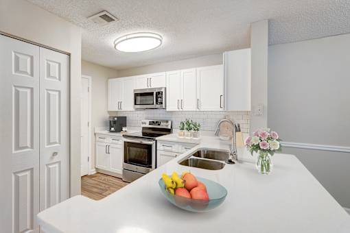 A kitchen with a bowl of fruit on the counter.