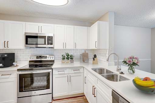 A kitchen with white cabinets and a stainless steel oven.