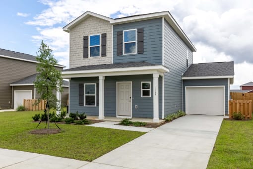 a blue house with a sidewalk in front of it