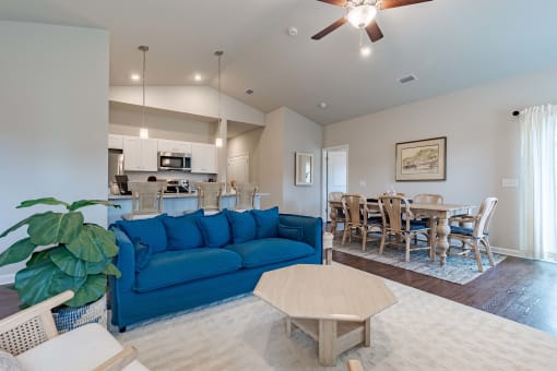 a living room with a blue couch and a dining room table