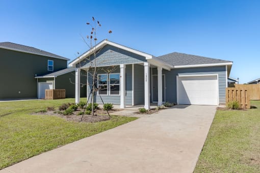 a blue house with a driveway and a white garage door
