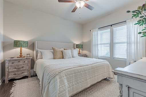 a bedroom with a large bed and a ceiling fan