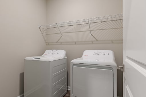 a washer and dryer in a laundry room with a rack on the wall