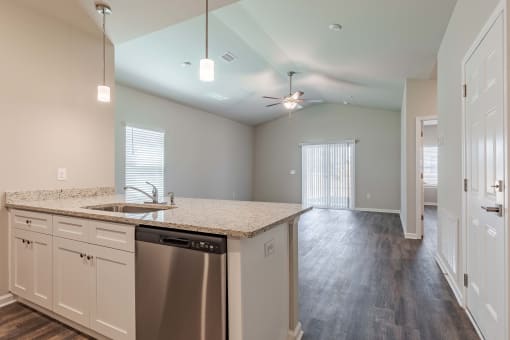 an empty kitchen with a counter top and a stainless steel dishwasher