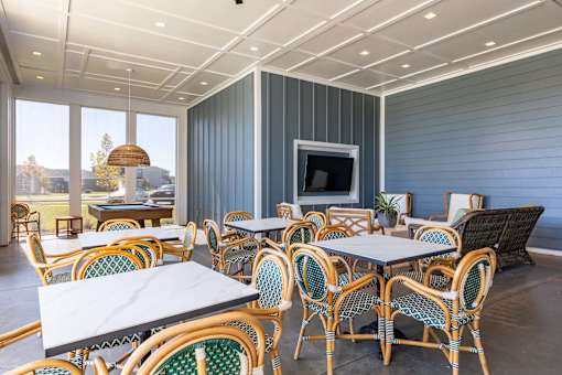 a patio with tables and chairs and a television