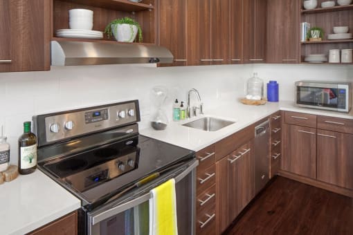 Studio Apartments in South Portland OR - Modern Kitchen With Wood Cabinetry, White Countertops, and Stainless Steel Appliances