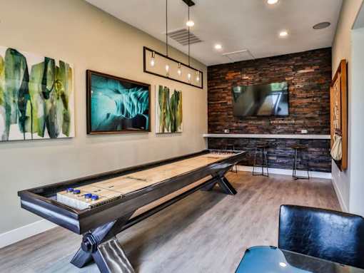 A room with a pool table and a bar area.