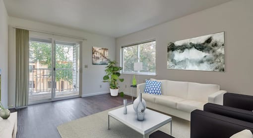 Coeur d' Alene, ID, Apartments For Rent - Living Room With Upgraded Wood-Style Flooring. Area Rug, Couch, Armchairs, Coffee Table, Wall Art, Houseplant, Window, And Sliding Glass Door With Balcony Access.