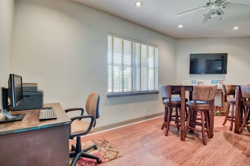Beaumont, TX Apartments – Breakwater Bay - Business Center with tables, chairs, tv, and computer