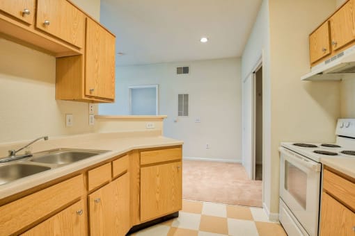Apartments In Beaumont, TX for Rent – Breakwater Bay - Kitchen with tile flooring, stainless steel sink, plenty of cabinets for storage, oven/stove top