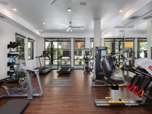 Fitness center with cardio and strength-training equipment at Santana Terrace apartments in Santa Clara
