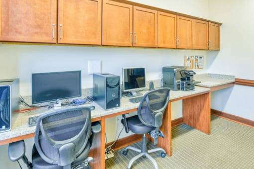 business center with two computers and two chairs