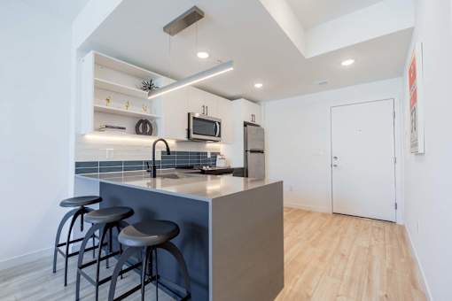 A kitchen with a bar stool and a counter.