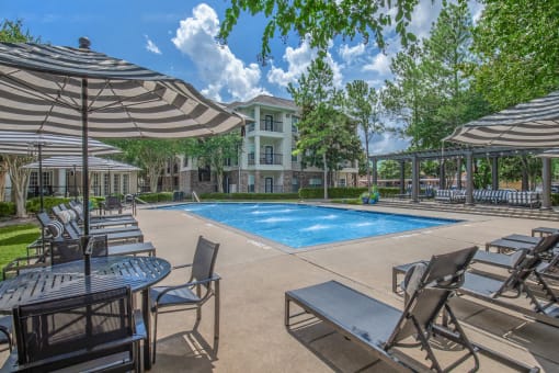 Affordable Houston Texas Apartments – Westchase Forest – Photo of our apartments offer a swimming pool with chairs and umbrellas