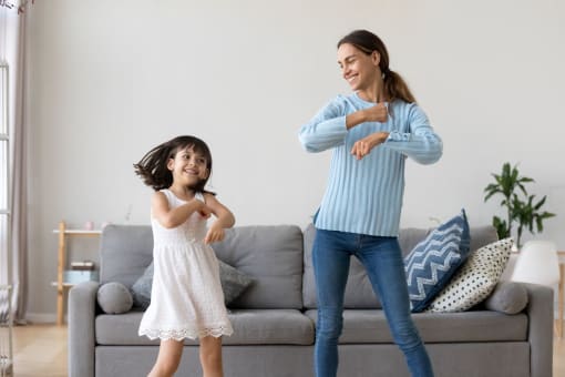 a mother and daughter playing interactive video games in a living room
