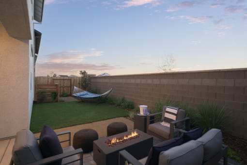 a backyard patio with a fire pit and a hammock