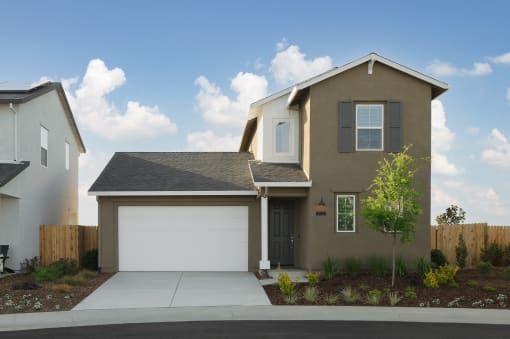 Roseville, CA Single Family Homes for Rent - Vera at Fiddyment - Frontage of Single-Family Home with Attached Garage, Driveway, Planted Trees, and Concrete Sidewalk.