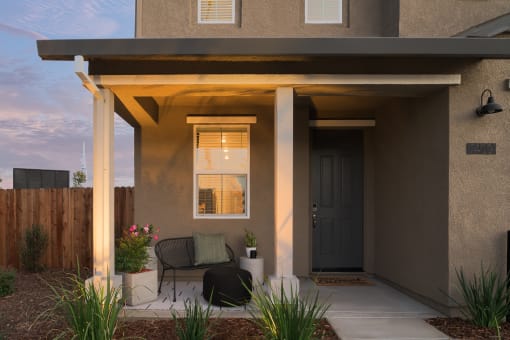 a patio with a table and chairs in front of a house