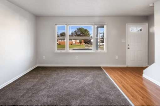A room with a view of a backyard through the window.