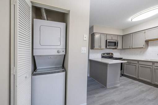 A white dishwasher is in a kitchen with a microwave and oven.