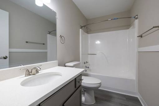 A bathroom with a toilet, sink, and shower.