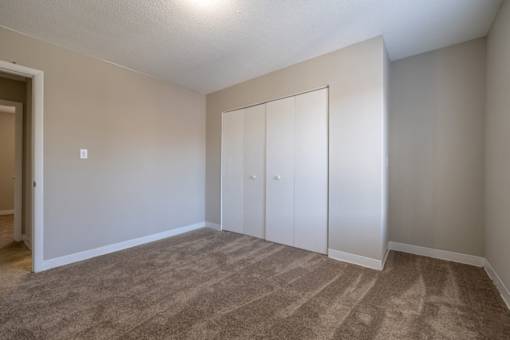 A room with carpeted floor and a white door.