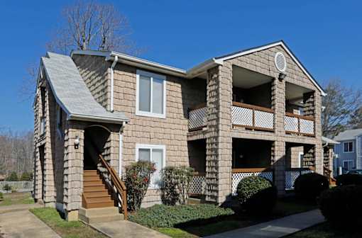 A two-story house with a balcony on the second floor.