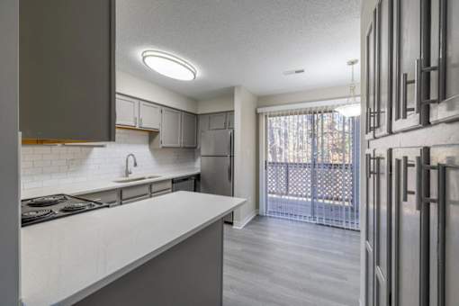 A modern kitchen with a stove top oven and a refrigerator.
