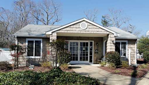 A house with a grey roof and a white fence.