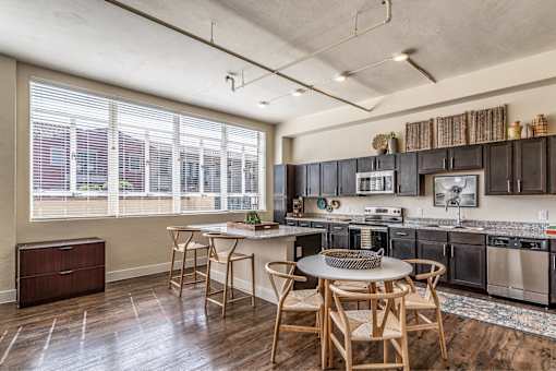 A kitchen with a table and chairs in front of a window.