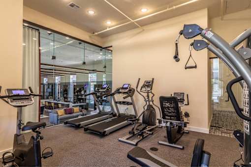 Affordable Apartments Near San Antonio River N Park San Antonio, TX - The St. John - A Gym With Matrix Cardio Equipment, A Functional Training Rack, And Resistance Bands, And Concrete Ceilings.