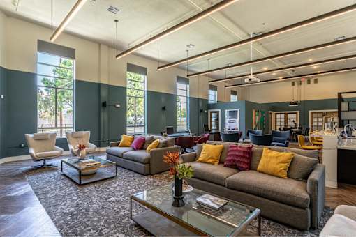 A living room with a grey couch and a glass coffee table.